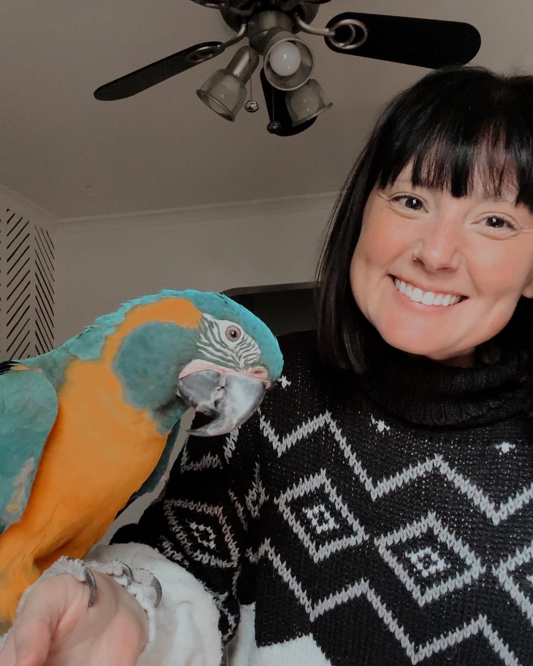 The Kya Project founder smiling at home with a blue-throated macaw